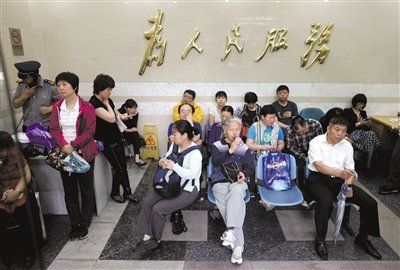6月7日，北京师范大学(微博)附属实验中学考点，家长们在考点对面的北京市公安局西城分局信访大厅避雨。新京报记者 薛珺 摄