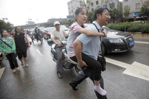 考试结束后下起了大雨，一名家长背着孩子出来